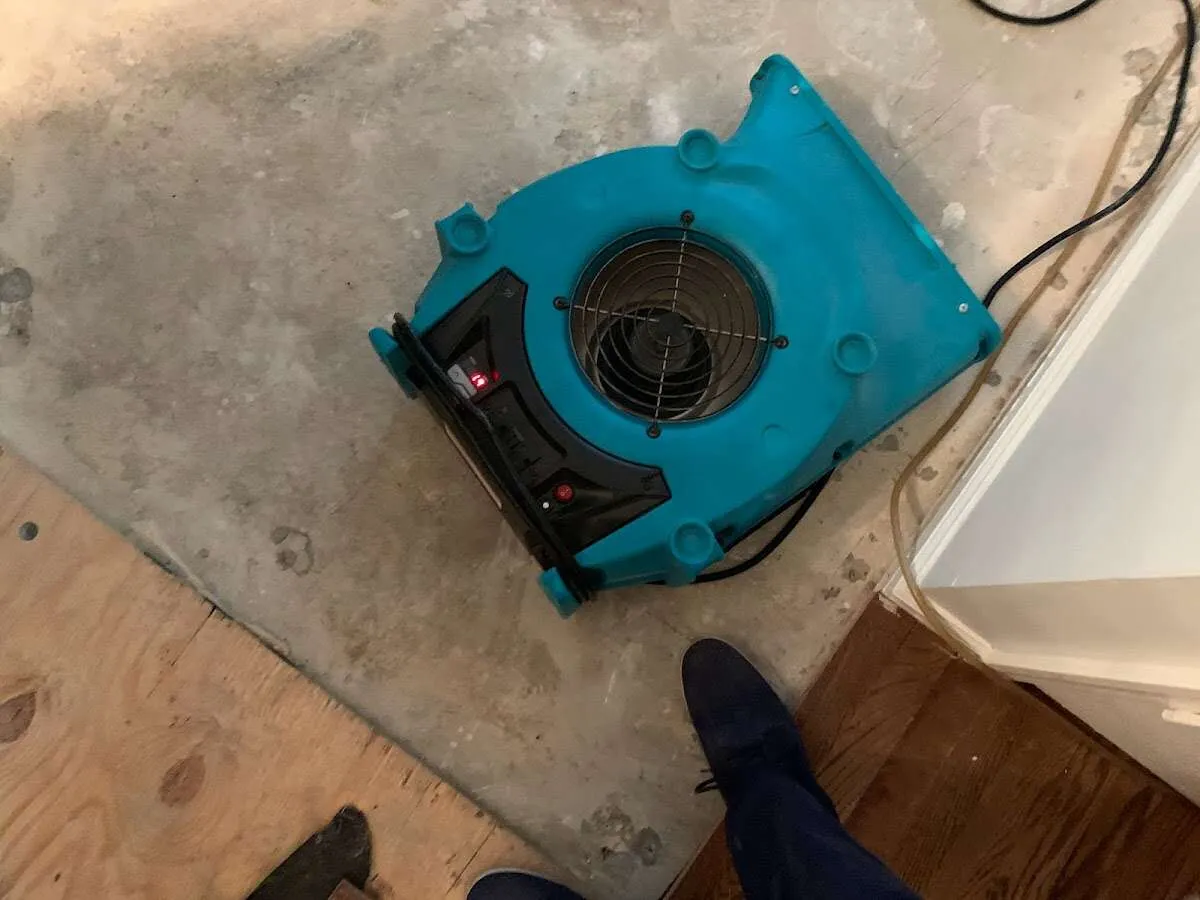 Air mover drying subfloor during Commercial Water Damage Restoration in Chicago